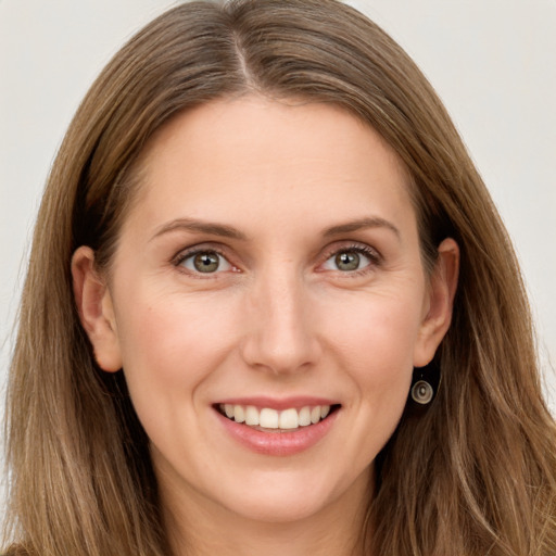 Joyful white young-adult female with long  brown hair and grey eyes