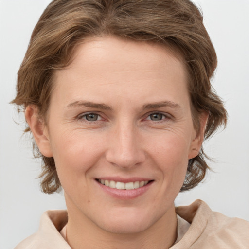 Joyful white young-adult female with medium  brown hair and grey eyes