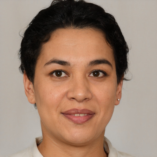 Joyful latino adult female with short  brown hair and brown eyes
