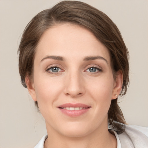 Joyful white young-adult female with medium  brown hair and grey eyes