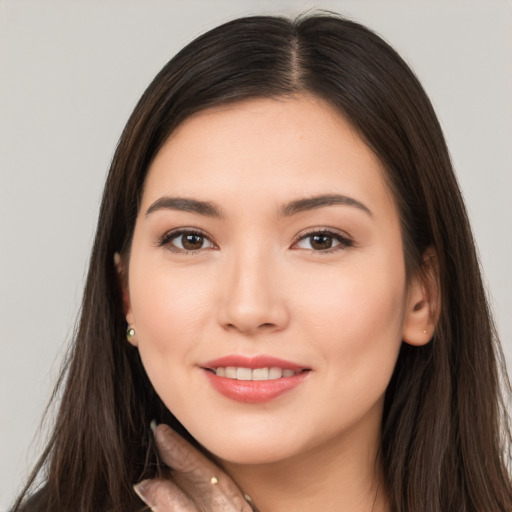 Joyful white young-adult female with long  brown hair and brown eyes