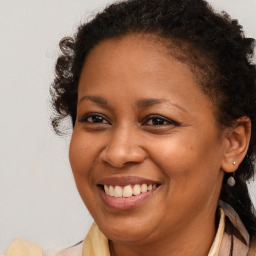 Joyful black young-adult female with long  brown hair and brown eyes