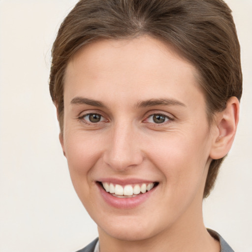 Joyful white young-adult female with short  brown hair and grey eyes