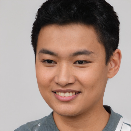Joyful asian young-adult male with short  black hair and brown eyes