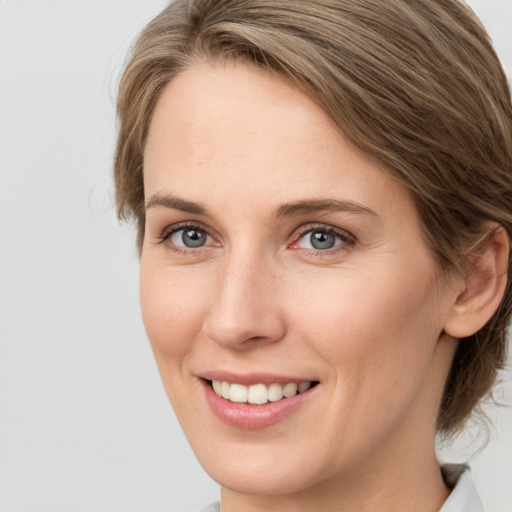 Joyful white young-adult female with medium  brown hair and green eyes