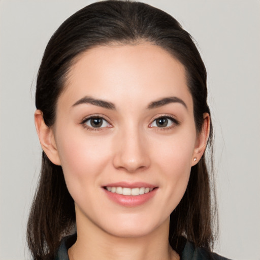 Joyful white young-adult female with long  brown hair and brown eyes