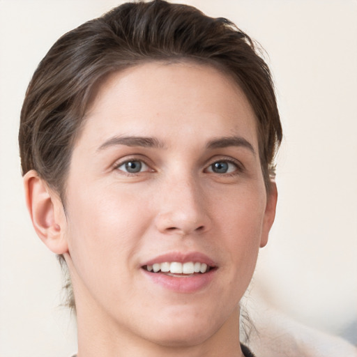 Joyful white young-adult female with short  brown hair and grey eyes