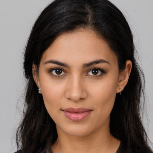 Joyful latino young-adult female with long  brown hair and brown eyes