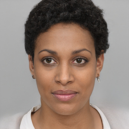 Joyful black young-adult female with short  black hair and brown eyes