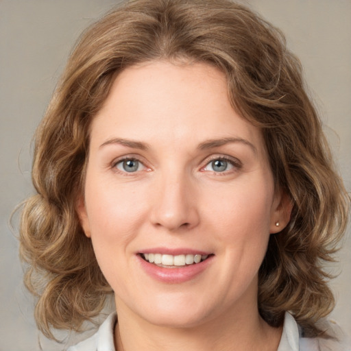 Joyful white young-adult female with medium  brown hair and blue eyes