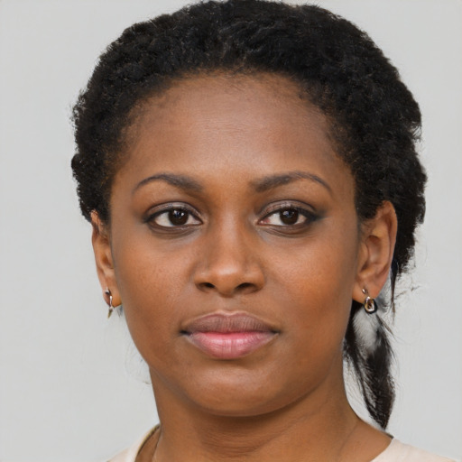 Joyful black young-adult female with short  brown hair and brown eyes