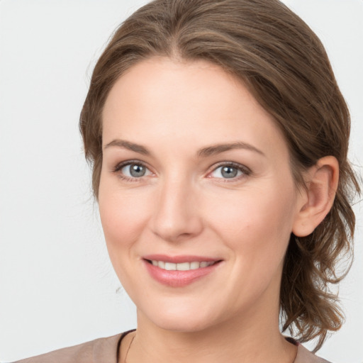 Joyful white young-adult female with medium  brown hair and grey eyes