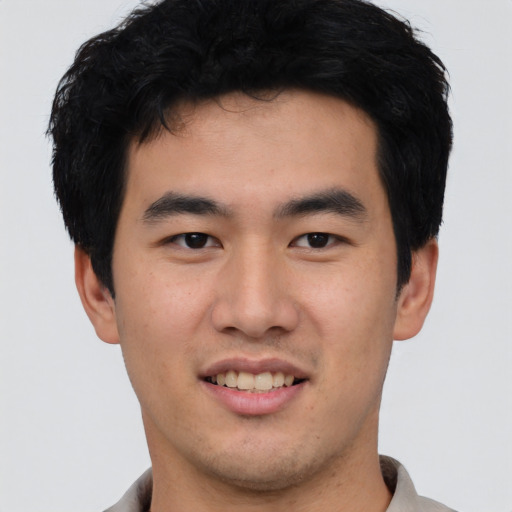 Joyful asian young-adult male with short  black hair and brown eyes