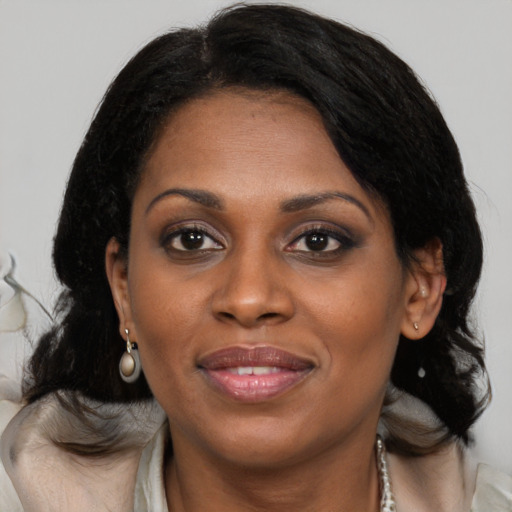 Joyful black adult female with medium  brown hair and brown eyes