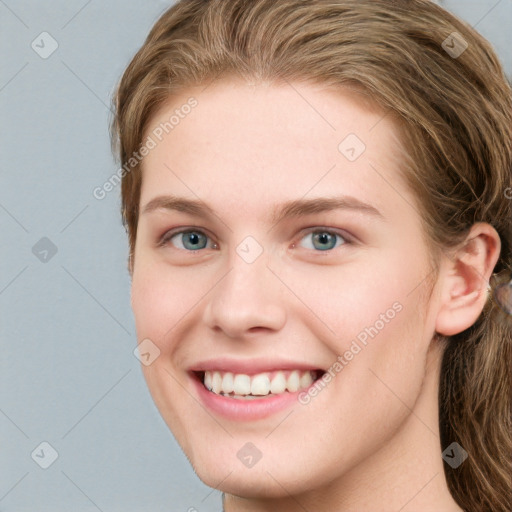 Joyful white young-adult female with long  brown hair and blue eyes