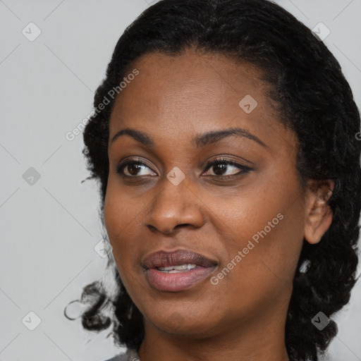 Joyful black young-adult female with long  black hair and brown eyes