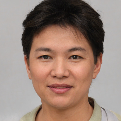 Joyful asian young-adult female with short  brown hair and brown eyes