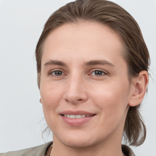 Joyful white young-adult female with medium  brown hair and grey eyes