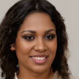 Joyful black young-adult female with long  brown hair and brown eyes