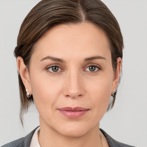 Joyful white young-adult female with medium  brown hair and grey eyes