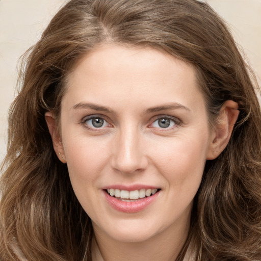 Joyful white young-adult female with long  brown hair and grey eyes