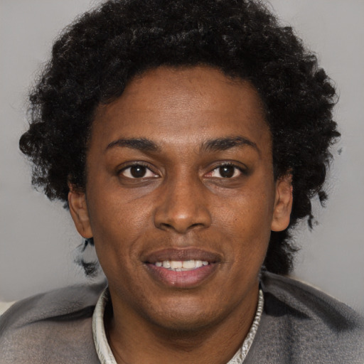 Joyful black adult female with short  brown hair and brown eyes