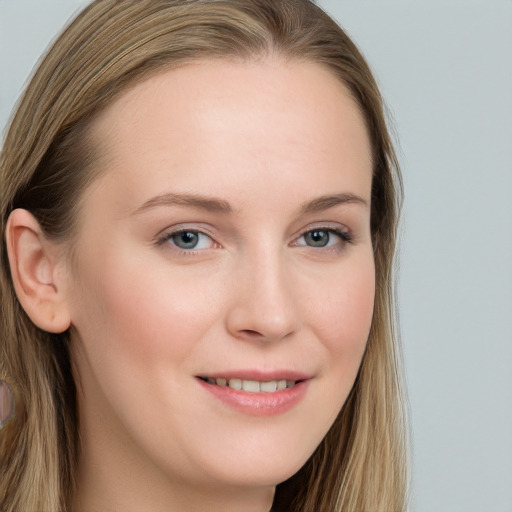 Joyful white young-adult female with long  brown hair and blue eyes