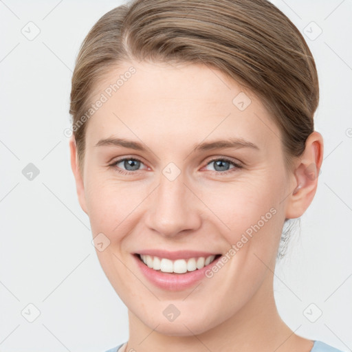 Joyful white young-adult female with medium  brown hair and blue eyes