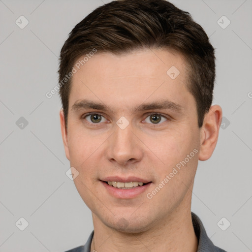 Joyful white young-adult male with short  brown hair and grey eyes