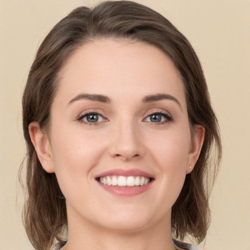 Joyful white young-adult female with medium  brown hair and green eyes