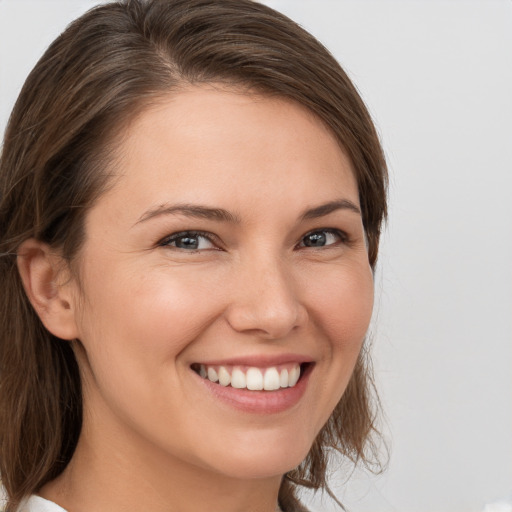 Joyful white young-adult female with medium  brown hair and grey eyes