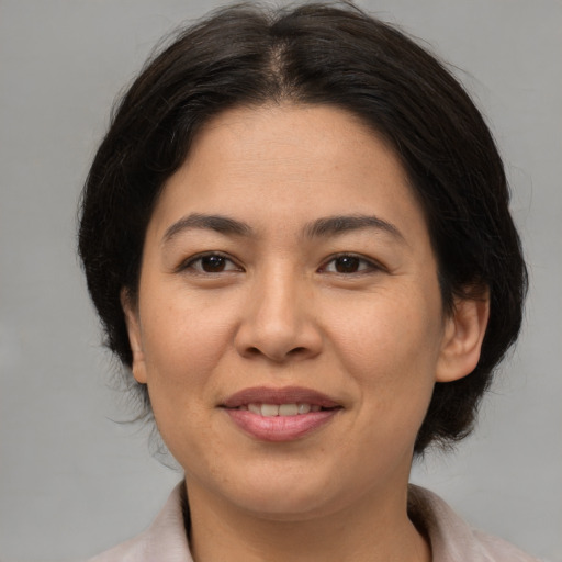 Joyful asian adult female with medium  brown hair and brown eyes