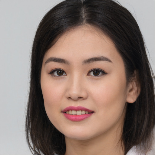 Joyful asian young-adult female with long  brown hair and brown eyes
