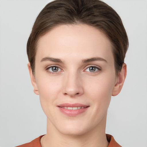 Joyful white young-adult female with short  brown hair and grey eyes