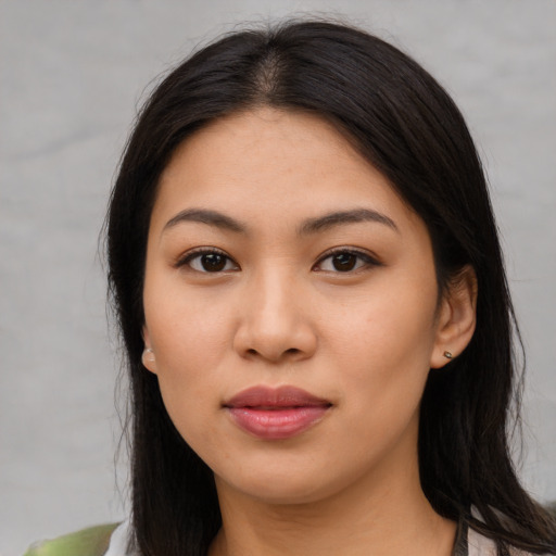 Joyful latino young-adult female with long  brown hair and brown eyes