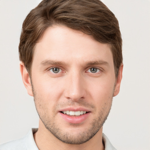 Joyful white young-adult male with short  brown hair and grey eyes