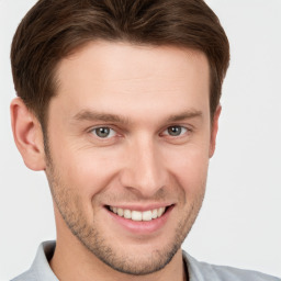 Joyful white young-adult male with short  brown hair and grey eyes