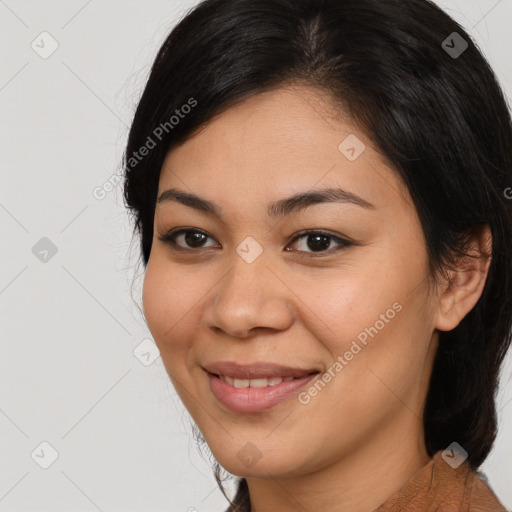 Joyful latino young-adult female with medium  brown hair and brown eyes