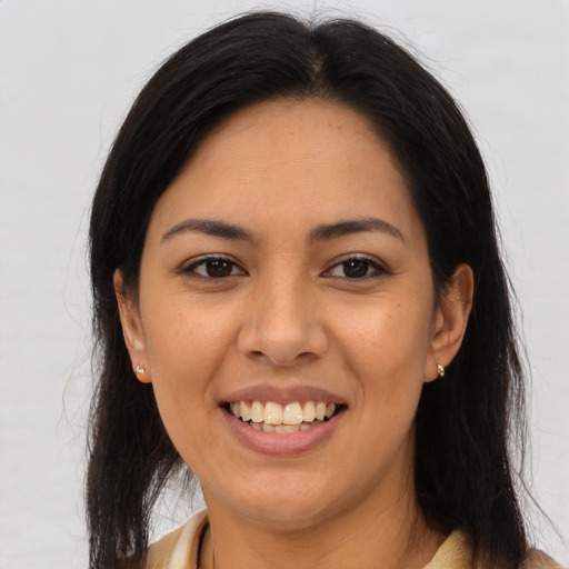 Joyful latino young-adult female with long  brown hair and brown eyes