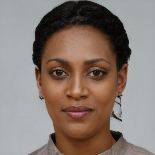 Joyful black young-adult female with short  black hair and brown eyes