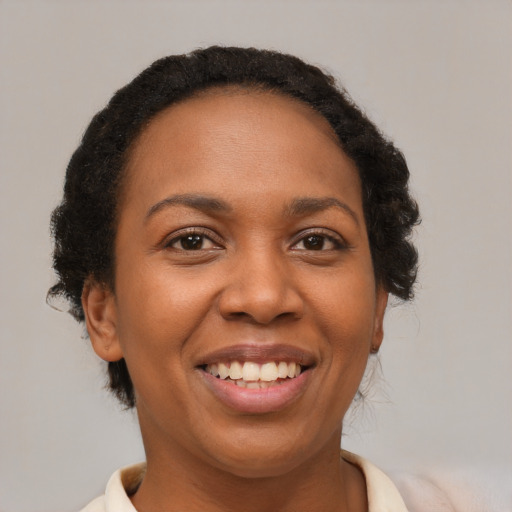 Joyful black young-adult female with medium  brown hair and brown eyes
