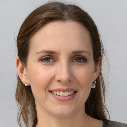 Joyful white young-adult female with medium  brown hair and grey eyes