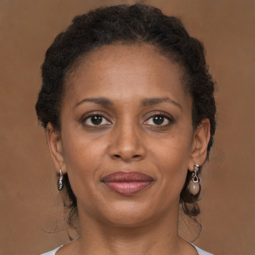 Joyful black adult female with long  brown hair and brown eyes