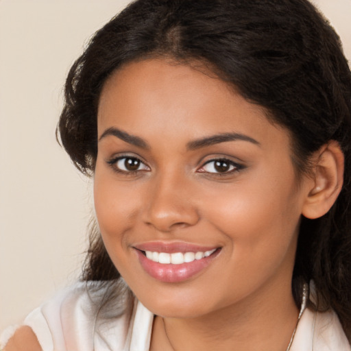 Joyful latino young-adult female with long  brown hair and brown eyes