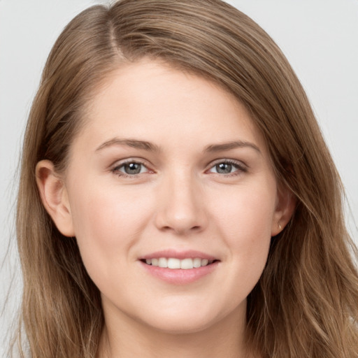 Joyful white young-adult female with long  brown hair and grey eyes