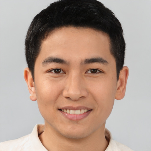 Joyful asian young-adult male with short  brown hair and brown eyes