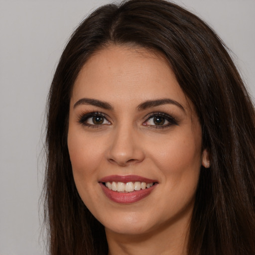 Joyful white young-adult female with long  brown hair and brown eyes