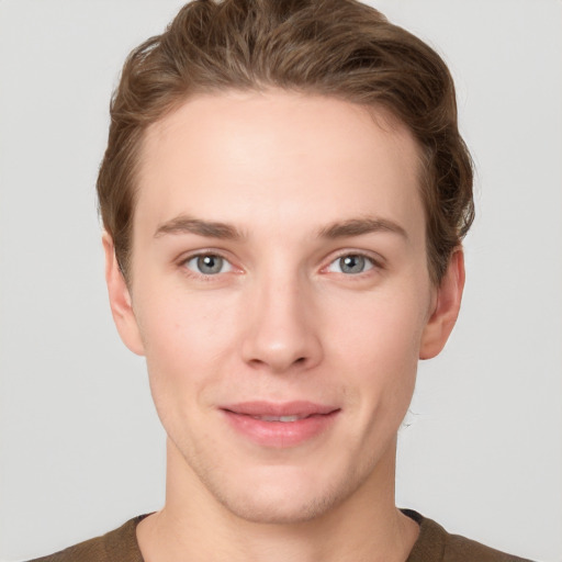 Joyful white young-adult male with short  brown hair and grey eyes