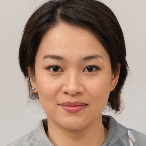 Joyful asian young-adult female with medium  brown hair and brown eyes