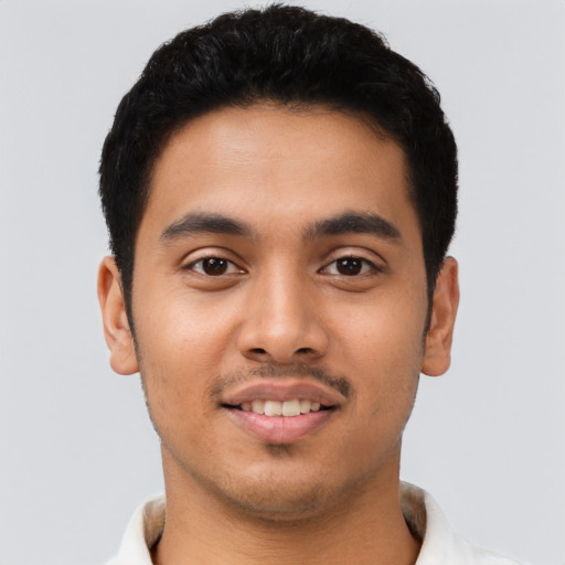 Joyful latino young-adult male with short  black hair and brown eyes